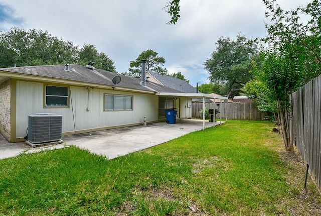 back of property featuring central AC unit, a patio area, and a lawn