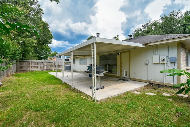 rear view of house with cooling unit, a lawn, and a patio