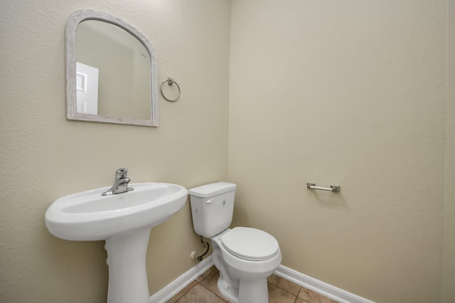 bathroom with toilet and tile patterned flooring