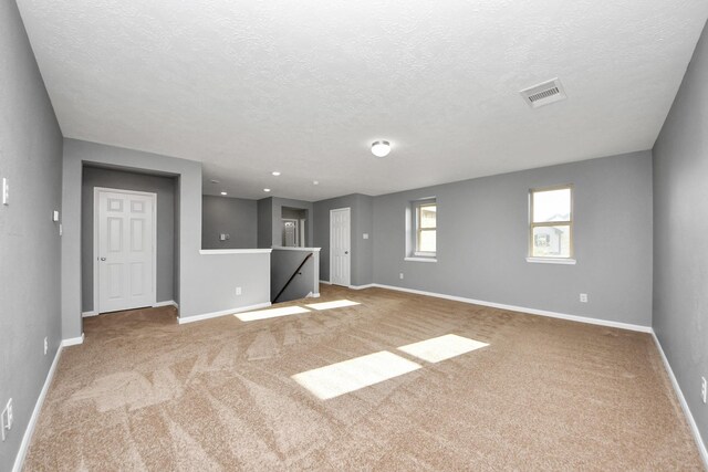 interior space featuring a textured ceiling and carpet flooring