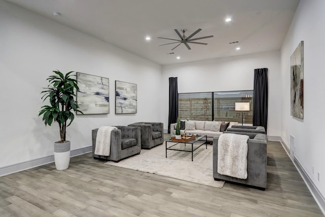 living room with ceiling fan and light hardwood / wood-style flooring