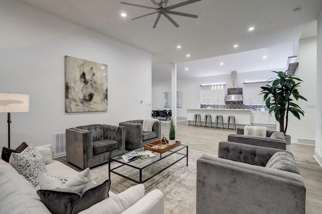 living room with light hardwood / wood-style flooring and ceiling fan