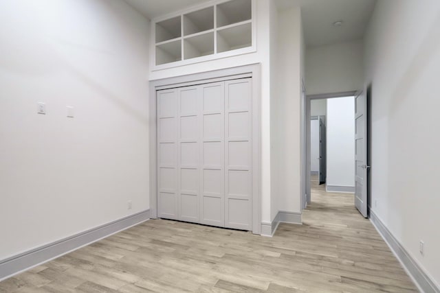 interior space featuring light hardwood / wood-style floors and a high ceiling