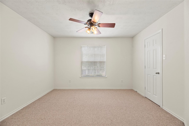 carpeted spare room featuring a textured ceiling and ceiling fan