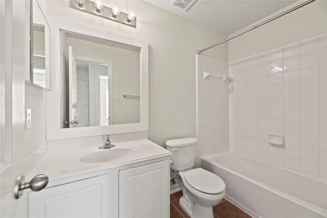 full bathroom featuring vanity, toilet, a textured ceiling, and tiled shower / bath