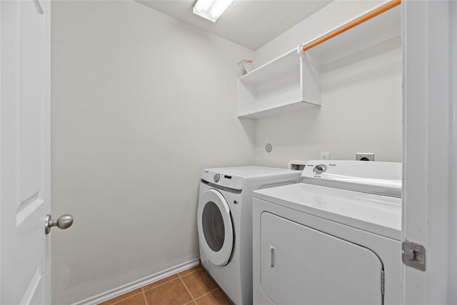 laundry area with independent washer and dryer and tile patterned flooring