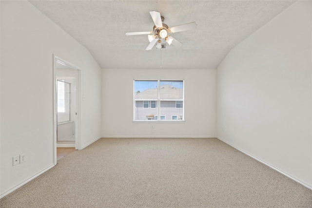 carpeted empty room with ceiling fan, lofted ceiling, a wealth of natural light, and a textured ceiling