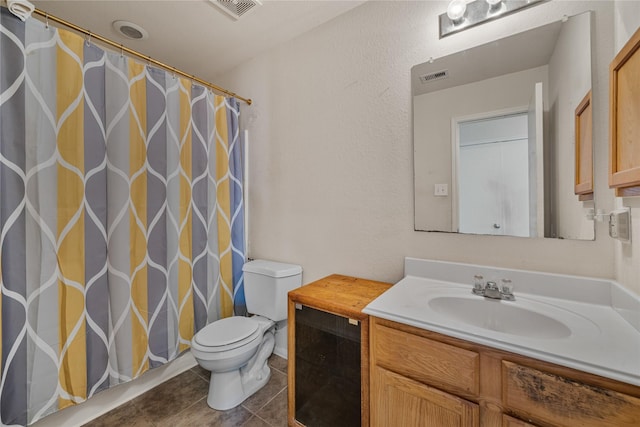 bathroom with vanity, toilet, and tile patterned flooring