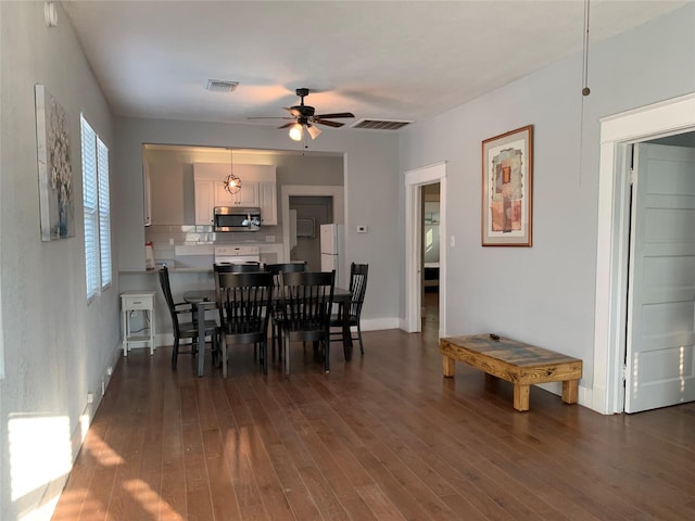 dining area with dark wood-type flooring and ceiling fan