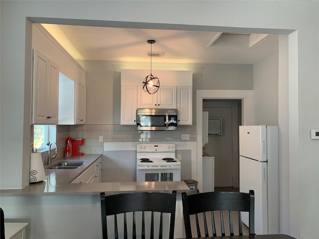 kitchen with decorative light fixtures, stacked washer / dryer, white cabinetry, sink, and white appliances