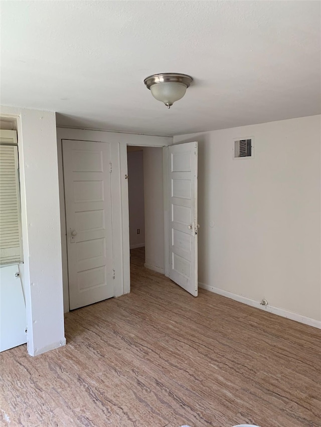 unfurnished bedroom featuring light hardwood / wood-style floors and a textured ceiling