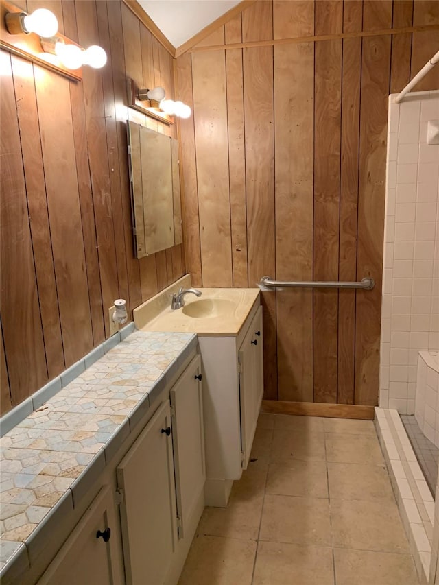 bathroom featuring vanity, tile patterned flooring, and wood walls