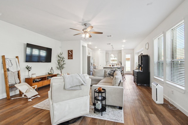 living room featuring ceiling fan and dark hardwood / wood-style flooring