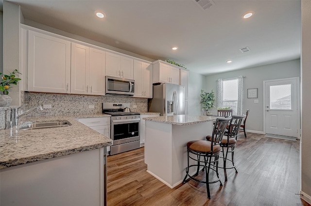 kitchen with sink, a center island, white cabinets, and appliances with stainless steel finishes