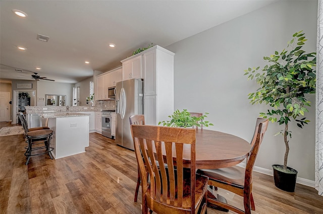 dining space featuring ceiling fan and light wood-type flooring