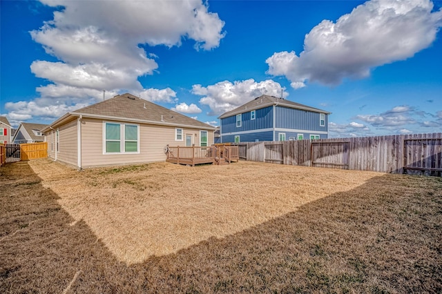 back of house with a wooden deck and a lawn