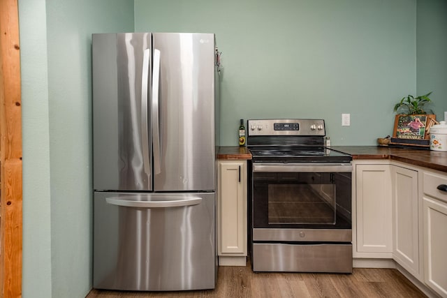 kitchen with white cabinetry, stainless steel appliances, and light hardwood / wood-style floors