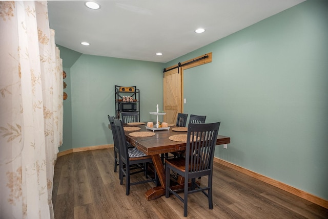 dining space featuring dark hardwood / wood-style floors and a barn door