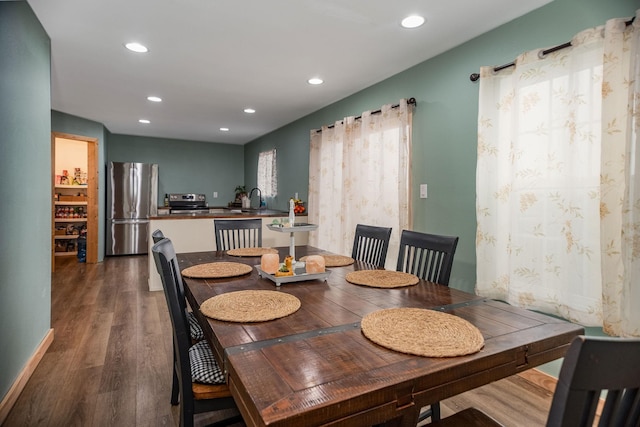 dining area with dark hardwood / wood-style floors and sink