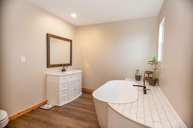 bathroom with vanity, hardwood / wood-style floors, and a washtub