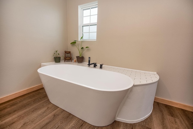 bathroom with hardwood / wood-style flooring and a bathing tub