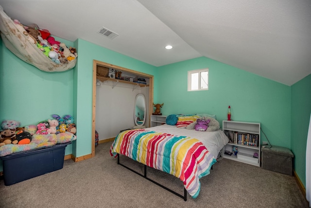 bedroom with carpet floors, vaulted ceiling, and a closet