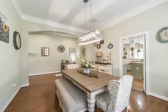 dining area with dark wood-type flooring and ornamental molding