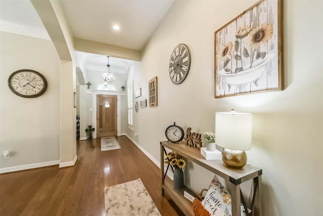 foyer entrance featuring dark hardwood / wood-style floors and a notable chandelier