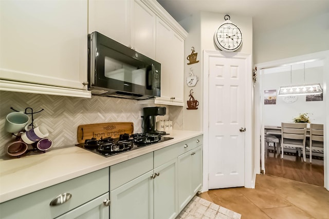 kitchen with white cabinetry, gas cooktop, tasteful backsplash, and light tile patterned floors