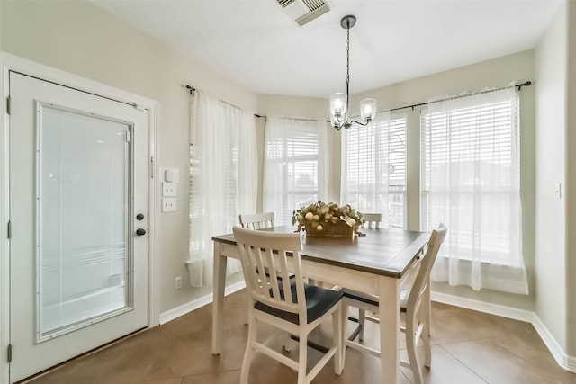 tiled dining space featuring an inviting chandelier