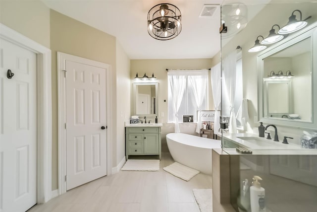 bathroom with vanity, tile patterned flooring, and a bathtub