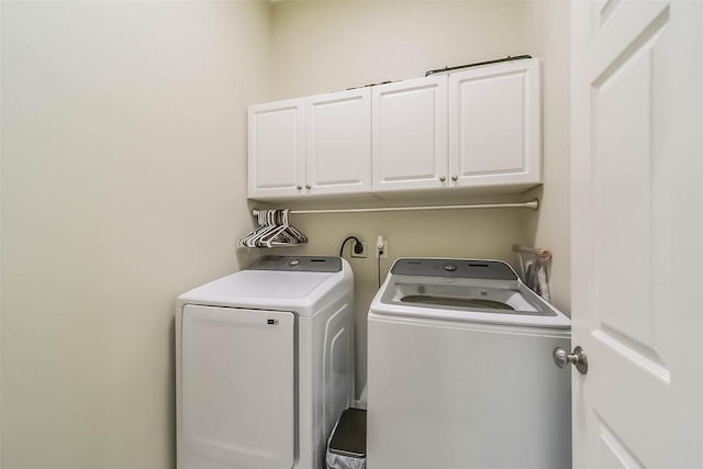 washroom featuring cabinets and independent washer and dryer