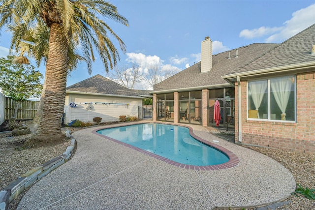 view of swimming pool with a patio and a sunroom