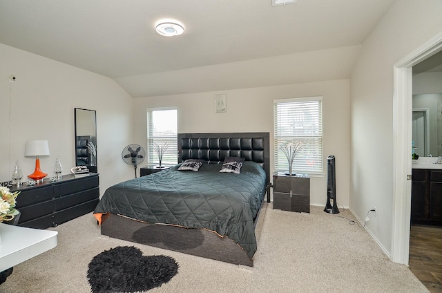 carpeted bedroom featuring lofted ceiling and multiple windows