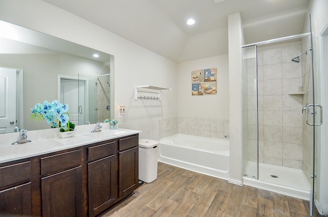 bathroom featuring vanity, wood-type flooring, lofted ceiling, and plus walk in shower