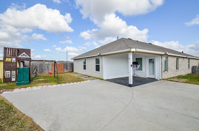 rear view of property featuring a playground and a yard