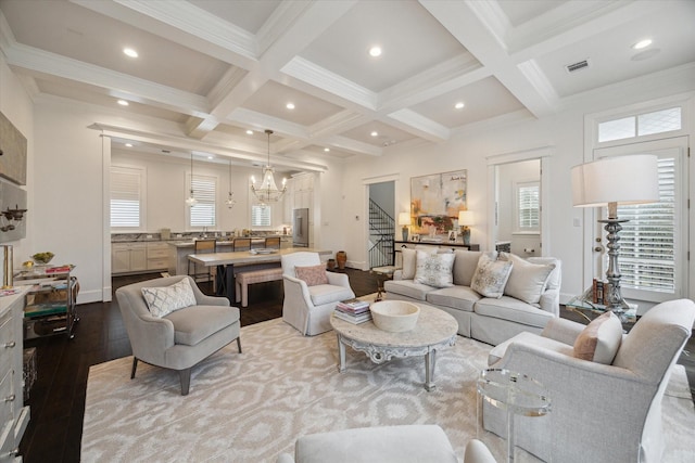 living room with crown molding, light hardwood / wood-style flooring, beam ceiling, coffered ceiling, and a notable chandelier