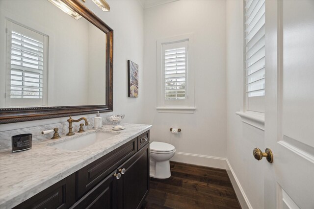 bathroom featuring vanity, hardwood / wood-style floors, toilet, and a healthy amount of sunlight