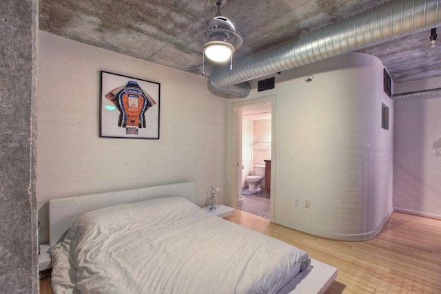 bedroom featuring ensuite bath, ceiling fan, and light wood-type flooring