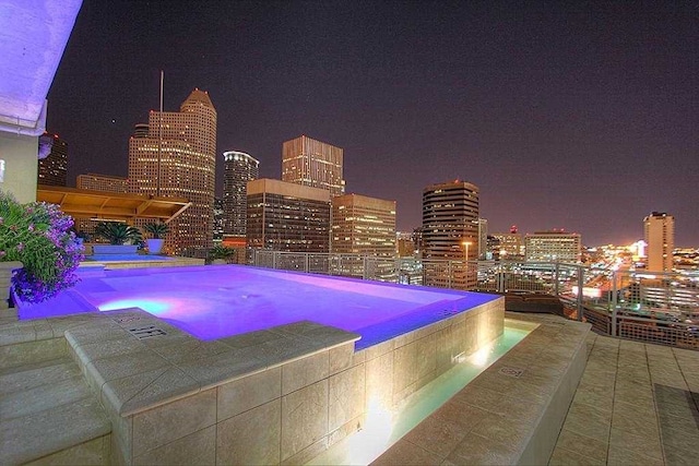 pool at twilight featuring a patio area