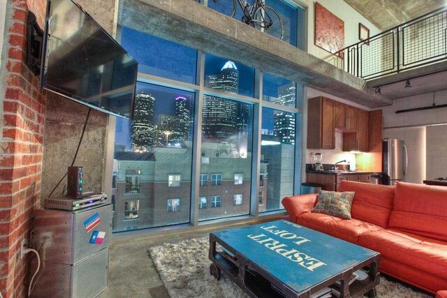 living room with concrete flooring and a high ceiling