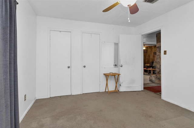 unfurnished bedroom with ceiling fan, light colored carpet, and two closets