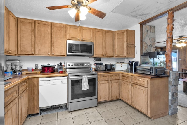 kitchen featuring ceiling fan, a textured ceiling, and appliances with stainless steel finishes