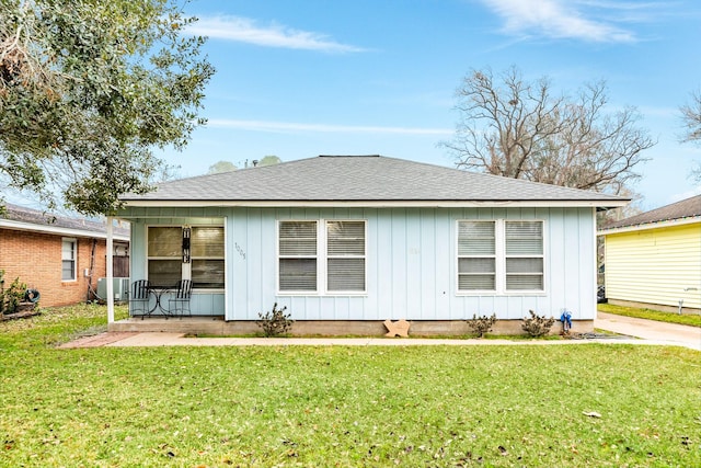 back of property featuring a yard and central AC