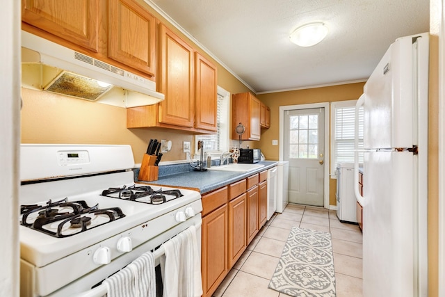 kitchen with light tile patterned flooring, separate washer and dryer, sink, crown molding, and white appliances