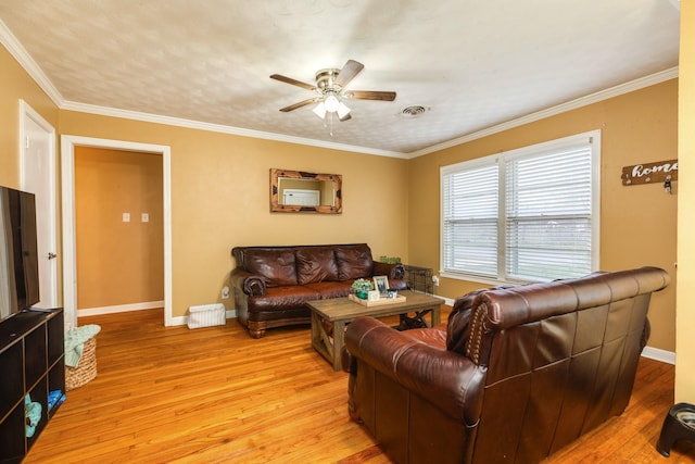 living room featuring ornamental molding, light hardwood / wood-style floors, and ceiling fan