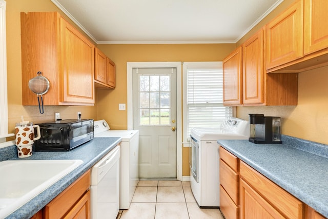 laundry area featuring crown molding, sink, light tile patterned floors, and washing machine and clothes dryer