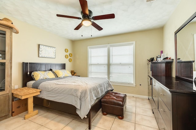 bedroom featuring light tile patterned flooring, ceiling fan, and a textured ceiling