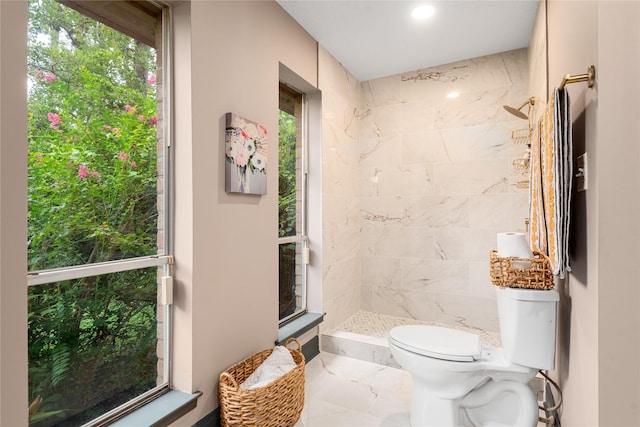 bathroom with tiled shower and toilet