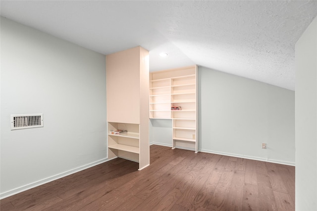 bonus room featuring wood-type flooring, lofted ceiling, and a textured ceiling